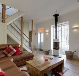 A living room with a sofa and a fireplace at Poppyfields Stable in Redruth