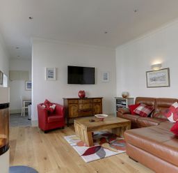 A living room with a fireplace and furniture at Poppyfields Stable in Redruth