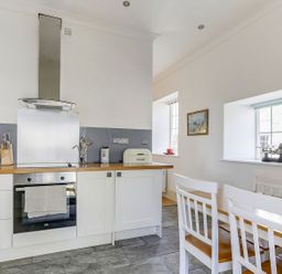 A kitchen with modern appliances and a dining table at Poppyfields Stable in Redruth