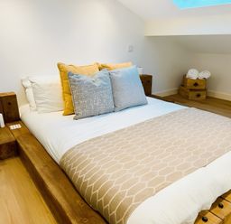 A bedroom with a bed and nightstands at Honey Bee Cottage in Welshpool