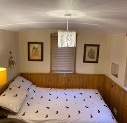 A bedroom with a bed and lamp at Shepherds hut in Dumfries