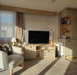 A living room with a television and armchair at Harbour View in Poole