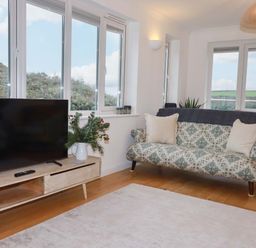 A living room with a television and sofa at Poldreth in Truro
