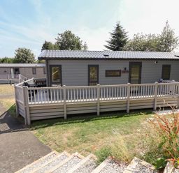 A mobile home with a deck and pathway at The Pines 3 Bedrooms Delamere