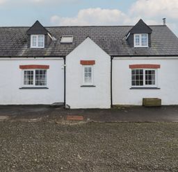 A cottage with windows and a driveway at Rhosgranog Cottage Llandeloy near Solva