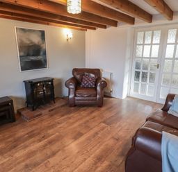 A living room with a fire place and two sofas at Rhosgranog Cottage Llandeloy near Solva