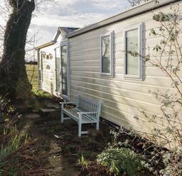An outdoor area with a caravan and a bench at Rhosgranog Caravan Llandeloy near Solva
