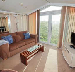 A living room with a sofa and coffee table at Rhosgranog Caravan Llandeloy near Solva