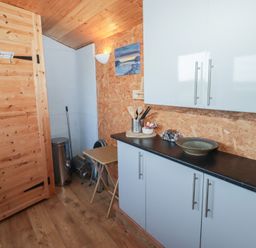 A kitchen with cabinets and a table at Rhosgranog Shepherds Hut in Llandeloy near Solva