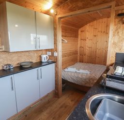A kitchen with a bed and cabinetry at Rhosgranog Shepherds Hut Llandeloy near Solva