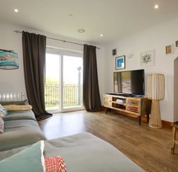 A living room with a television on a TV stand at Lowenna Watergate Bay near Newquay