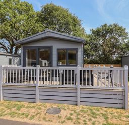 An outdoor view of a cabin with decking and railing at The Oaks 2 Bedrooms Delamere