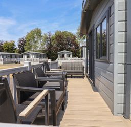An outdoor area with seating and a view of cabins at The Oaks 2 Bedrooms Delamere