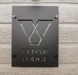 A sign displaying the name Cedar Lodge on a wooden wall