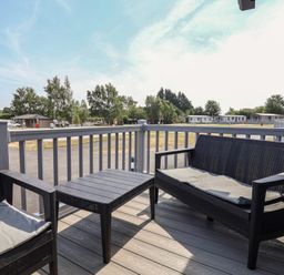An outdoor patio with seating and a table at Cedar Lodge 2 Bedrooms Delamere