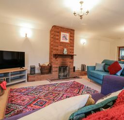 A living room with a TV and fireplace at The Pantiles in Banham