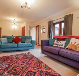 A living room with sofas and a rug at The Pantiles in Banham