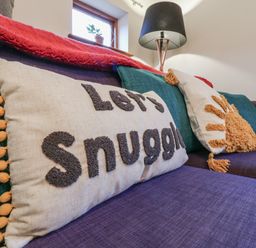 A living room with a couch and decorative pillows at The Pantiles in Banham