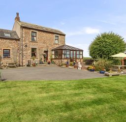 A house with a conservatory and garden at Bank House Cottage Glasson Dock