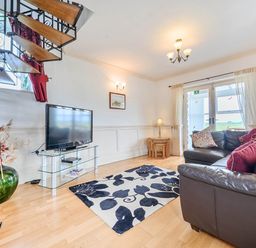 A living room with a sofa and television at Bank House Cottage Glasson Dock