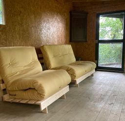 A seating area with two sofas and a window at The Tree House in the Woods Longhope