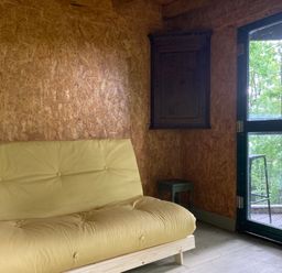 A snug with a yellow sofa and a cabinet at The Tree House in the Woods Longhope