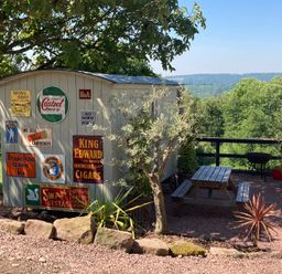 A garden area with a shed and picnic table at Cosy Shepherd’s Hut Longhope