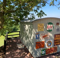 A shed with signs in an outdoor area at Cosy Shepherd’s Hut in Longhope
