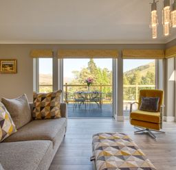 A living room with a sofa and a table at Pinemarten Lodge in Crianlarich