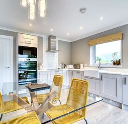 A kitchen with a table and chairs at Pinemarten Lodge Crianlarich