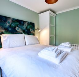 A bedroom with a bed and towels at Pinemarten Lodge in Crianlarich