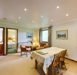 A dining room with table and chairs at Buzzard Lodge in Crianlarich