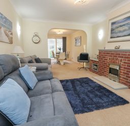 A living room with a sofa and a fireplace at Tudor Rose in Weymouth