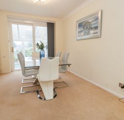 A dining room with a table and chairs at Tudor Rose in Weymouth
