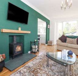 A living room with a fireplace and television at Wansfell View in Ambleside