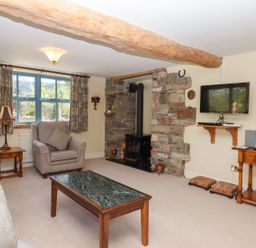 A living room with a fireplace and television at Pillars Barnstaple