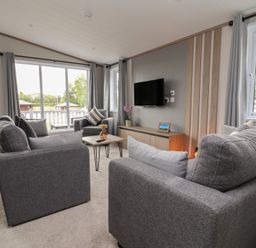 A living room with sofa and television at Cedar Lodge 3 Bedrooms Delamere