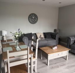 A living room with a table, chairs, and a sofa at 43 Goose Green Road in King's Lynn