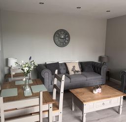 A living room with a sofa and dining table at 43 Goose Green Road in King's Lynn