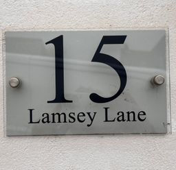 A sign displaying the address 15 Lamsey Lane