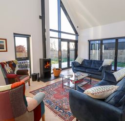 A living room with a sofa and fireplace at 1 Dairy Fields in Longframlington