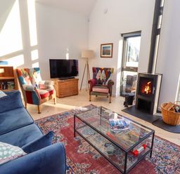 A living room with a sofa and television at 1 Dairy Fields Longframlington