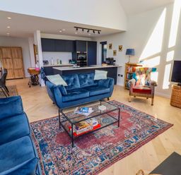 A living room with a sofa, coffee table, and television at 1 Dairy Fields Longframlington