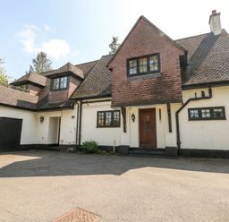 A house with a garage and garden at Woodlands house in Ringwood