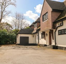 A house with a garage and driveway at Woodlands house in Ringwood