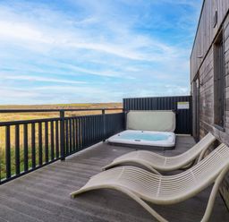 An outdoor area with a hot tub and deck chairs at 114 - The Residance Redruth