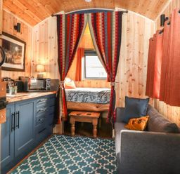A bedroom with a bed and sofa at Dunfell Shepherd's Hut in Appleby-In-Westmorland