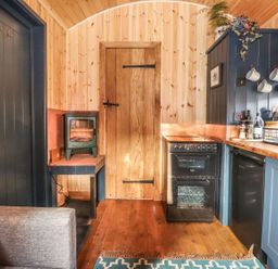 A kitchen with a stove and refrigerator at Dunfell Shepherd's Hut Appleby-In-Westmorland