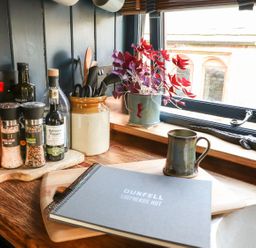 A kitchen counter with spices and a notebook at Dunfell Shepherd's Hut in Appleby-In-Westmorland