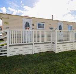 A mobile home with a porch and stairs at Whispering Meadows - 104 Hemsby